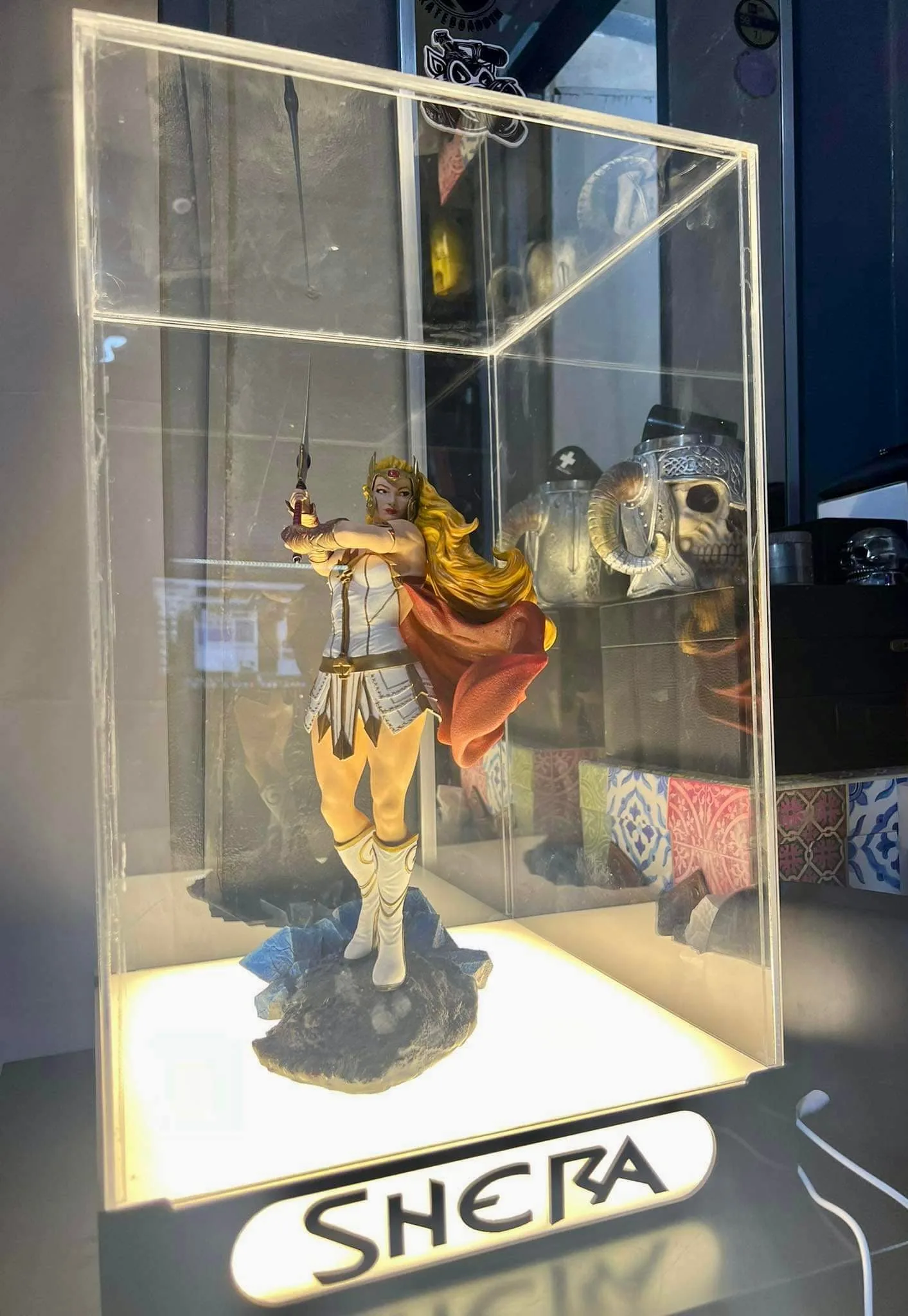 She-Ra figure in a lit glass cabinet